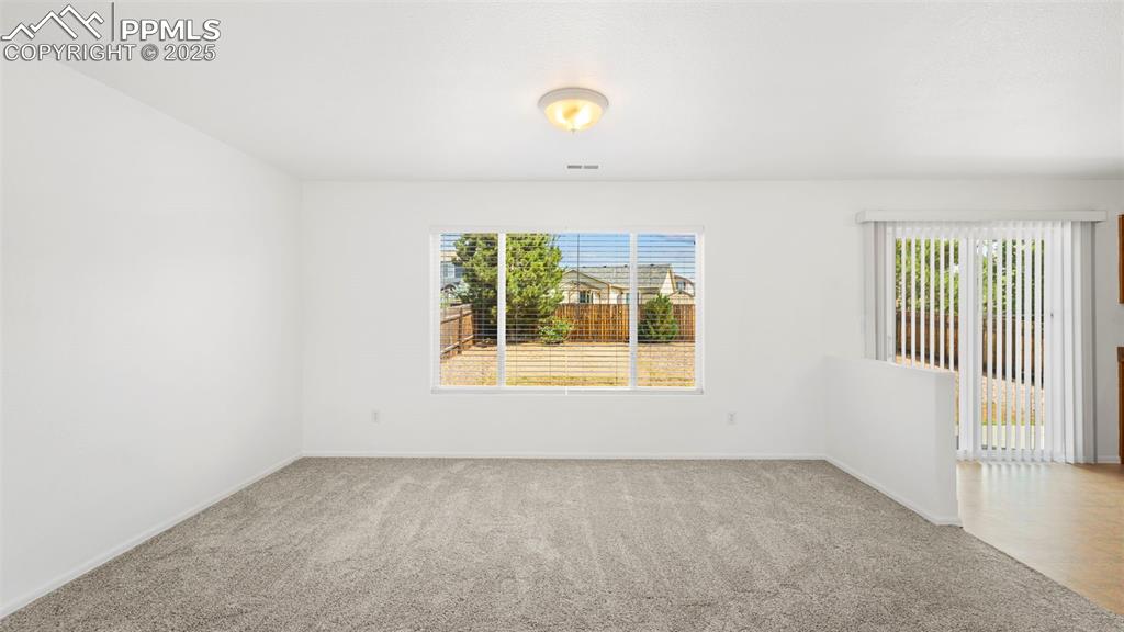 Image 9 of 46: Unfurnished room with plenty of natural light and carpet flooring