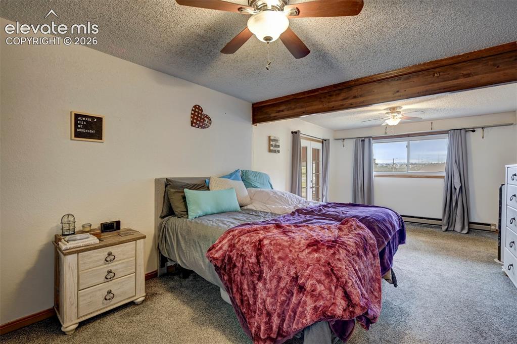 Image 14 of 50: Carpeted flooring, exposed wood beam, ceiling fan with integrated lighting,