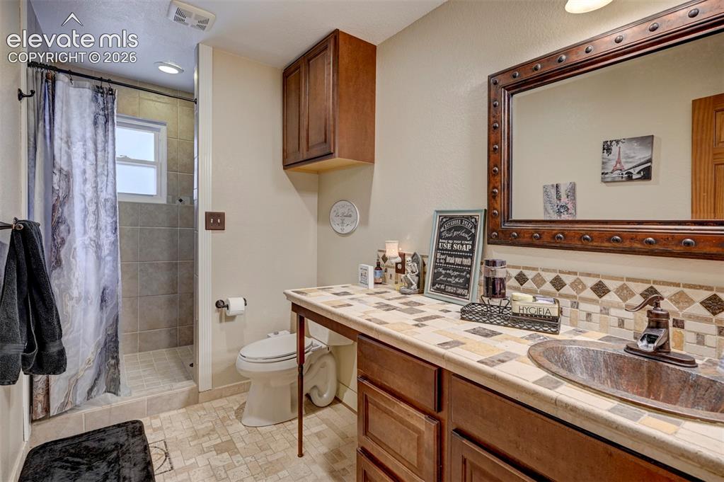 Image 21 of 50: Tile-surround shower with window, integrated recessed lighting, wood-finish