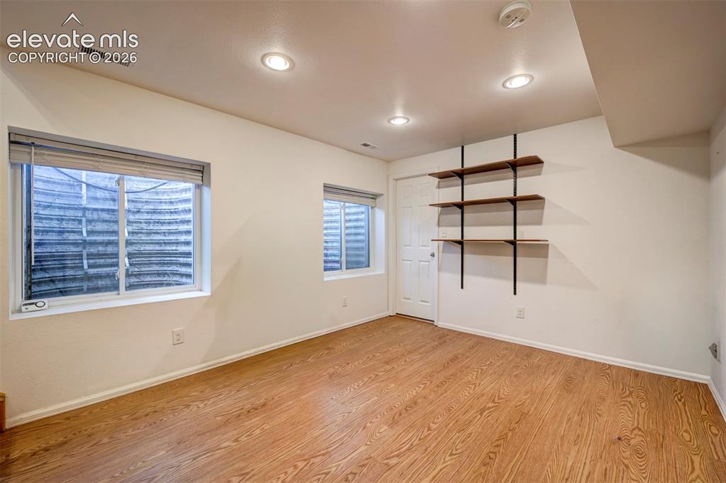 Image 29 of 50: Wood-finish flooring, recessed ceiling lighting, built-in shelving, white p