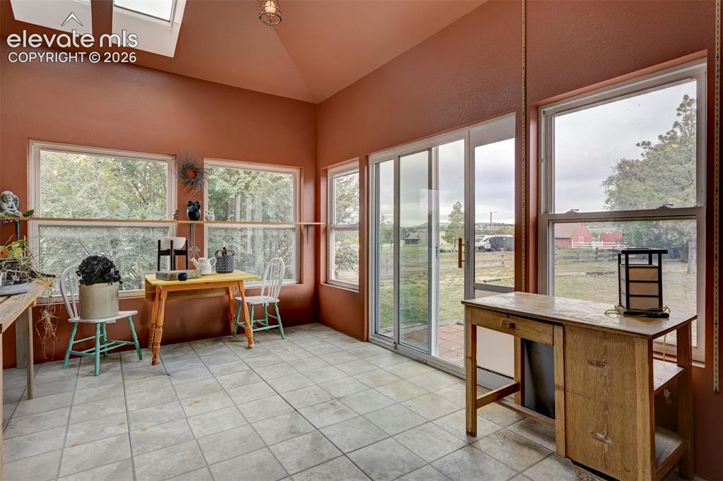 Image 33 of 50: Vaulted ceiling with skylights, extensive window placement, sliding glass d