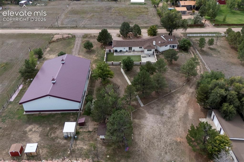 Image 45 of 50: Expansive property featuring a large white residence, separate barn structu