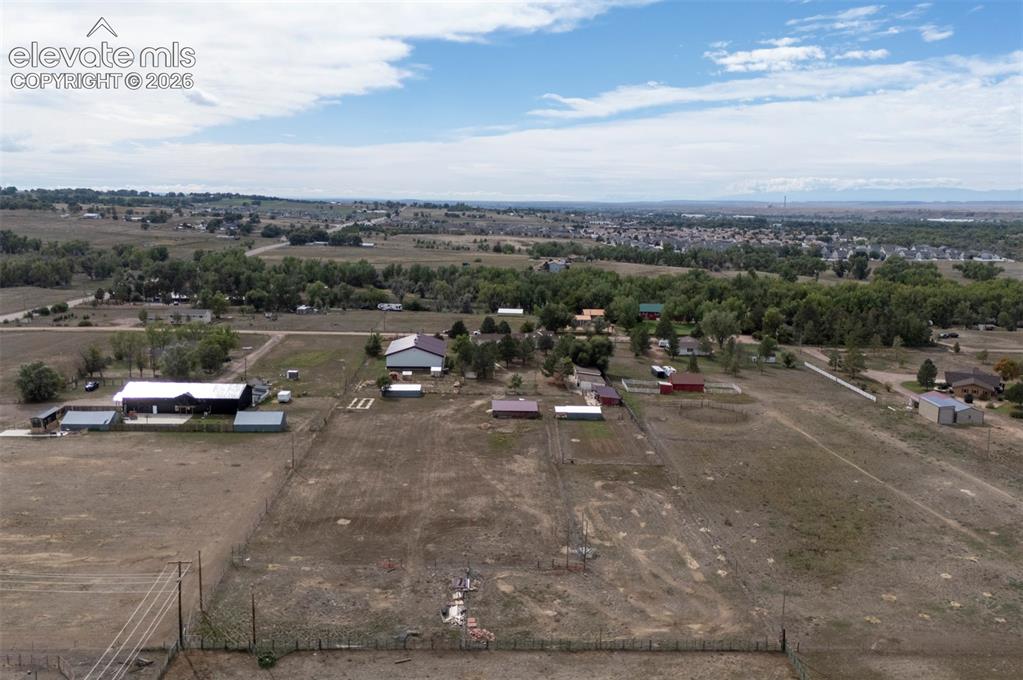 Image 46 of 50: Expansive property featuring multiple outbuildings, fenced areas, and open 
