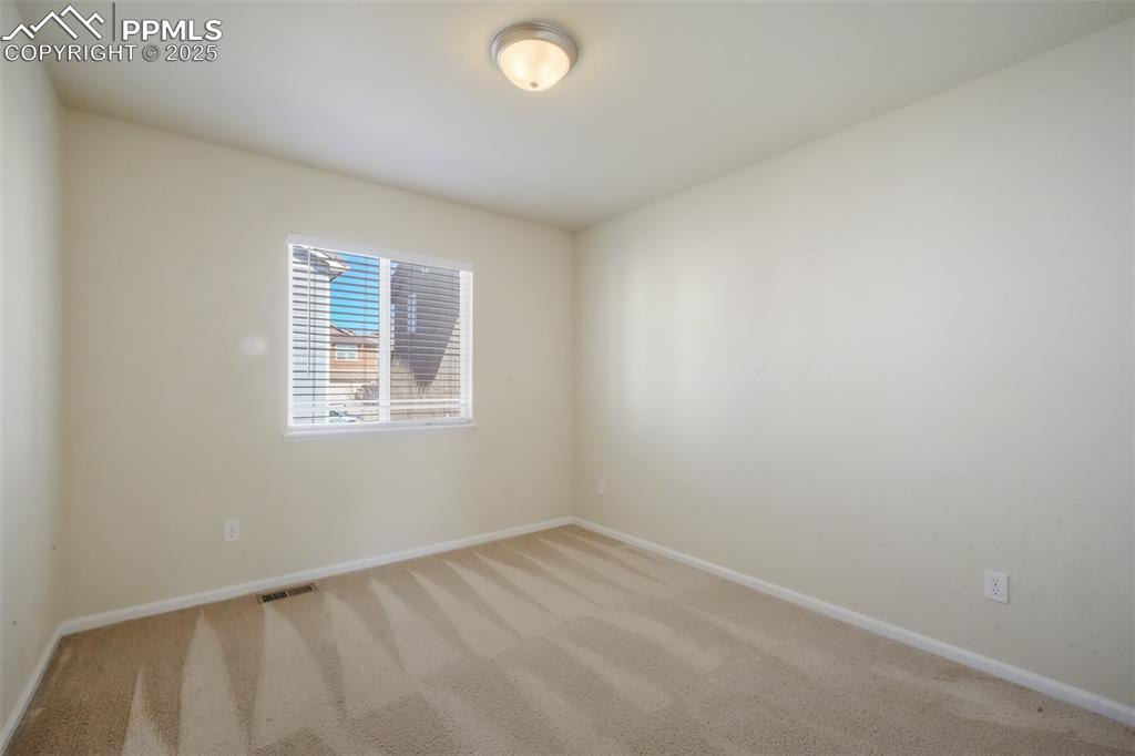 Image 26 of 50: Carpeted empty room featuring visible vents and baseboards