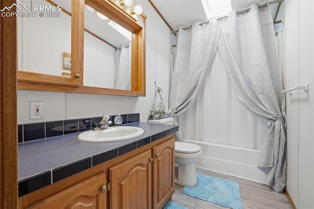 Image 26 of 49: Bathroom featuring shower / bathtub combination with curtain, vanity, and w