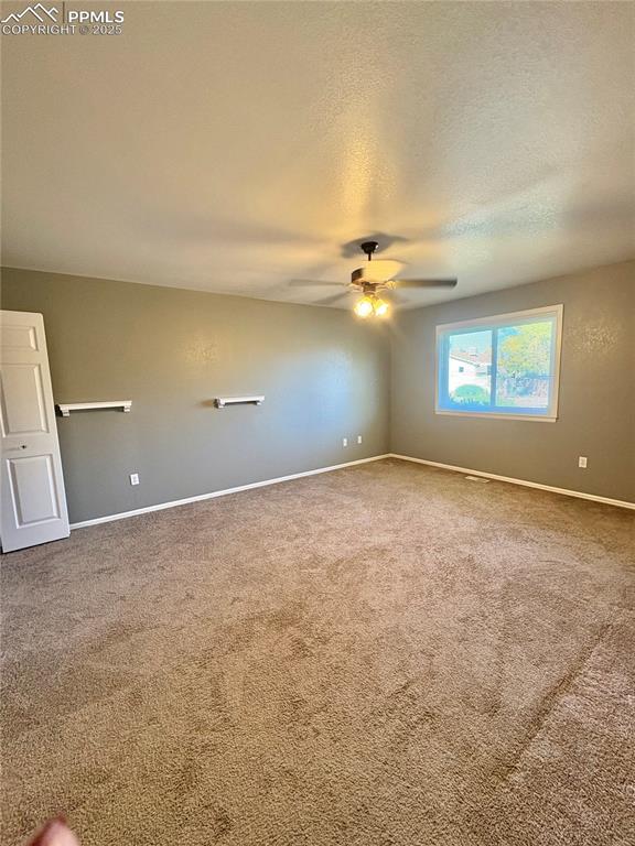 Image 20 of 25: Unfurnished room featuring carpet, a textured ceiling, and a ceiling fan