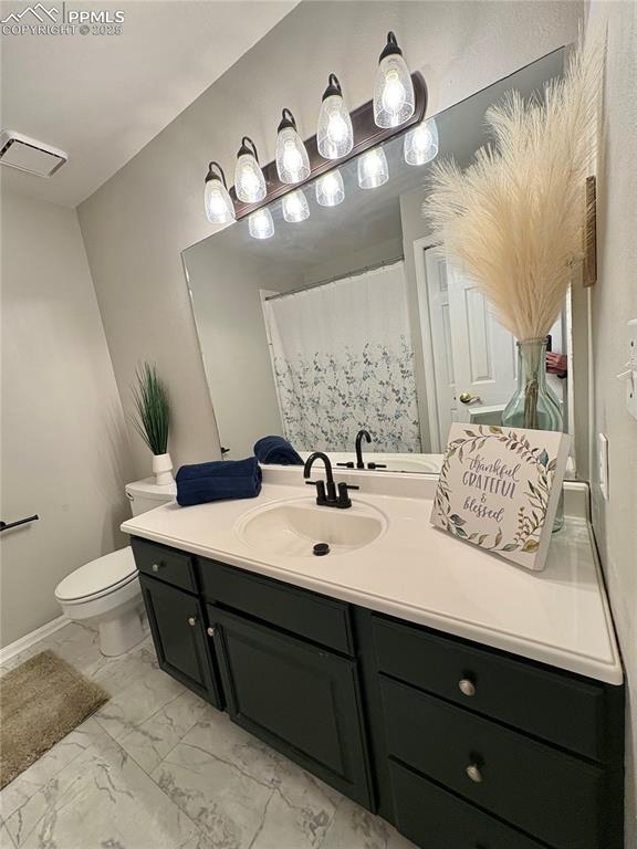 Image 21 of 27: Full bath with vanity, light marble finish floors, and a shower with curtai