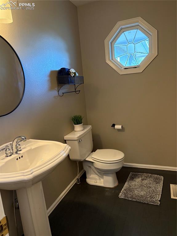 Image 23 of 27: Bathroom featuring toilet and baseboards
