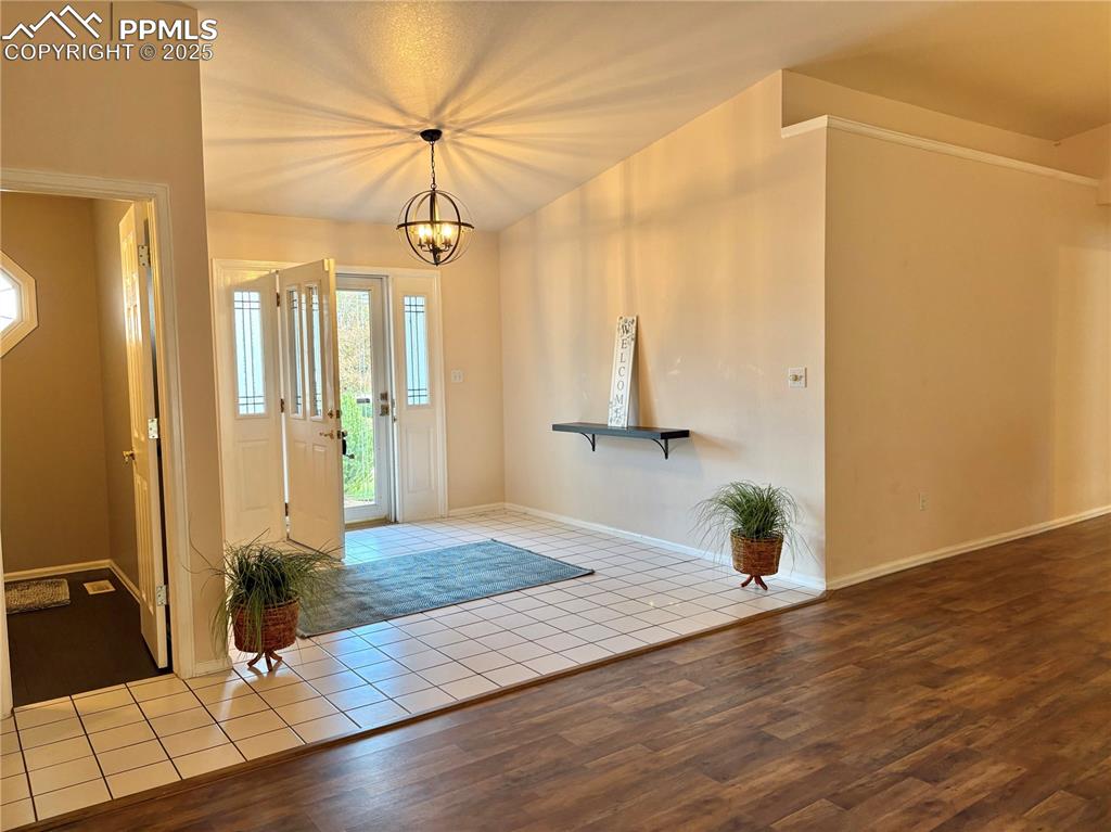Image 8 of 25: Foyer featuring tile patterned flooring and a chandelier