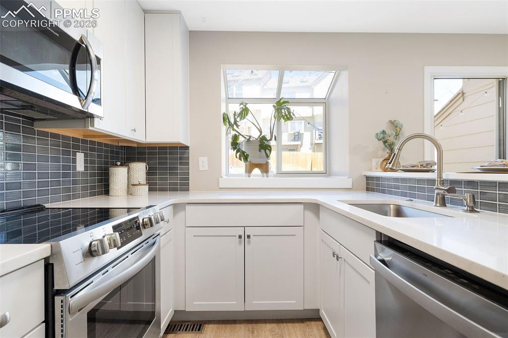 Image 11 of 26: Modern kitchen with white cabinetry and light countertops