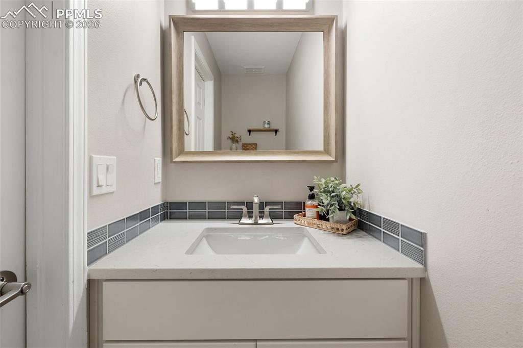 Image 13 of 26: Bathroom vanity featuring a light-colored countertop, integrated sink, and 