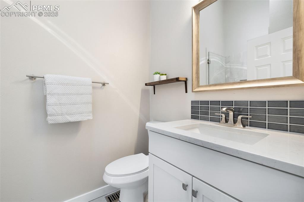Image 17 of 26: Bathroom vanity featuring a rectangular undermount sink, a light-colored co