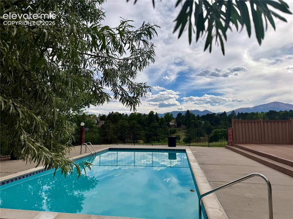 Image 27 of 30: Outdoor community  swimming pool with integrated steps, surrounded by concr