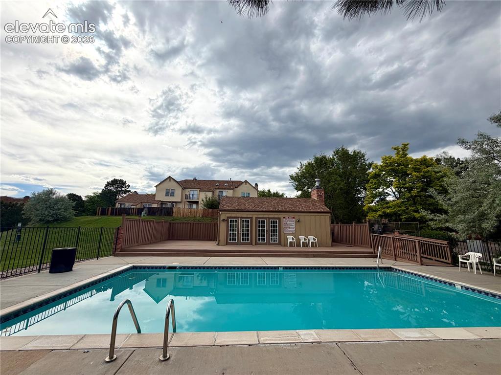 Image 29 of 30: Outdoor swimming pool with integrated steps and metal handrails