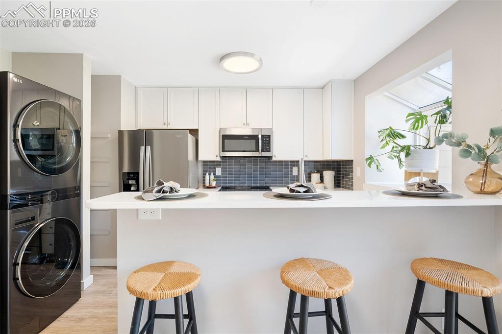 Image 9 of 26: Kitchen featuring white shaker cabinetry, stainless steel appliances, and a