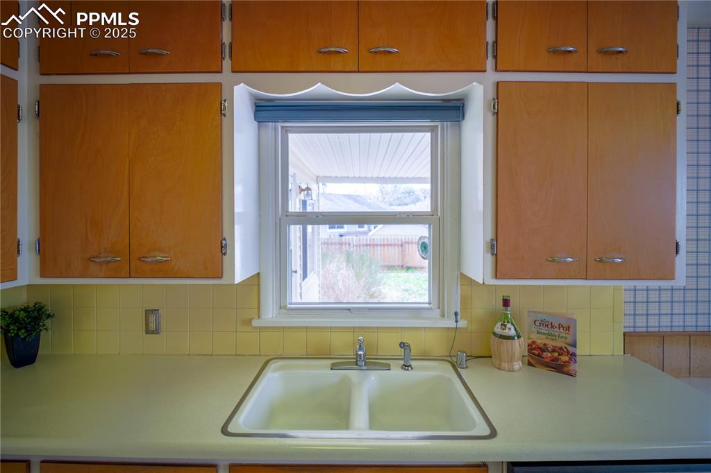 Image 13 of 28: Kitchen sink has a lovely window looking to the backyard