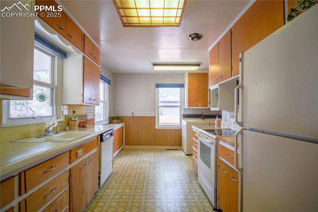 Image 14 of 28: Believed to be original cabinets and vinyl flooring