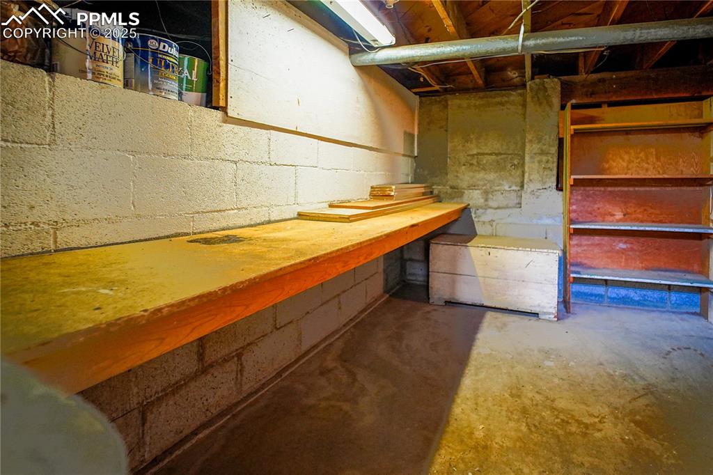 Image 25 of 28: Work or hobby space located in the basement/cellar area