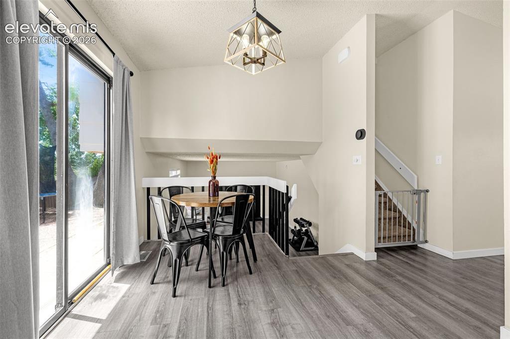 Image 10 of 29: Dining area featuring wood-finish flooring and a contemporary geometric pen