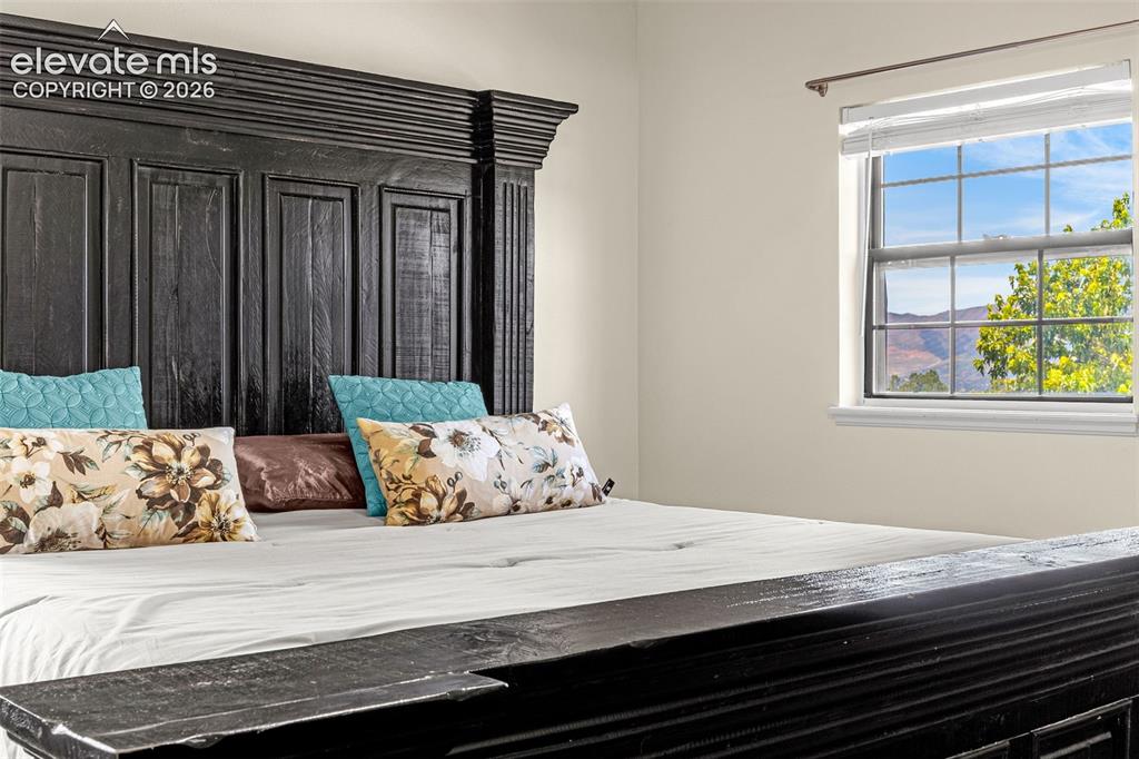 Image 15 of 29: Bedroom featuring a window with a mountain and tree backdrop