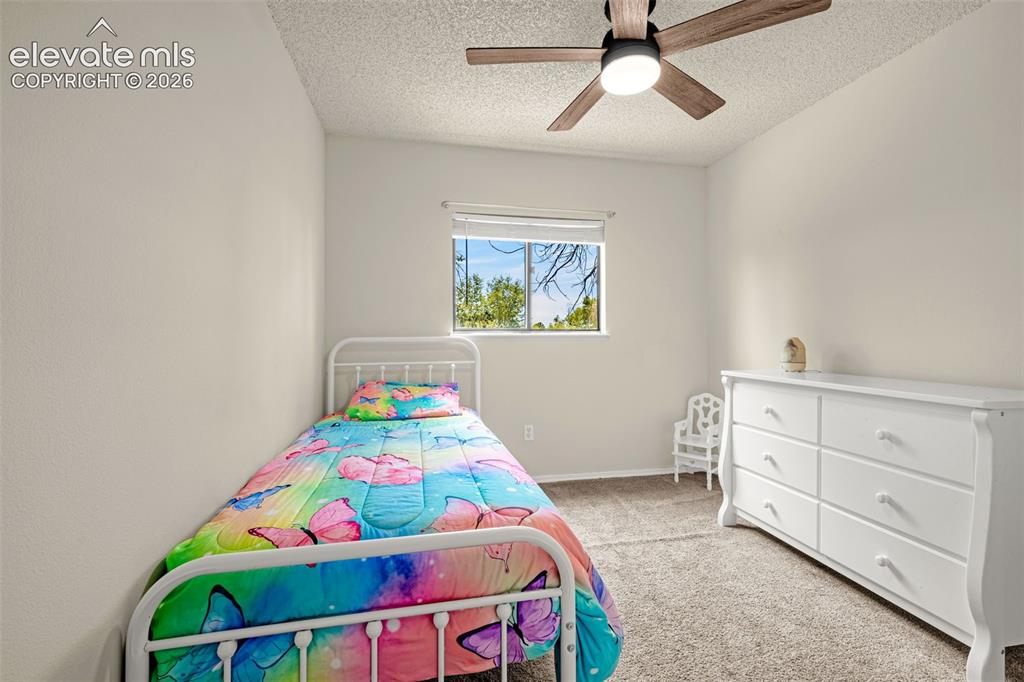 Image 17 of 29: Carpeted interior room featuring a window with white blinds, a ceiling fan