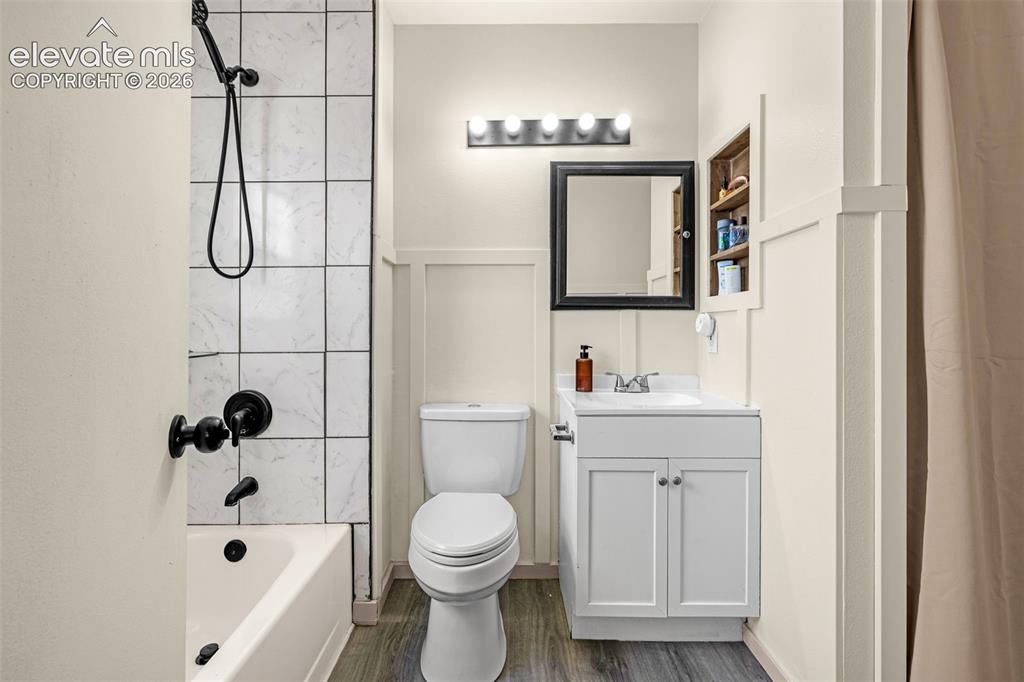Image 19 of 29: Bathroom featuring a white vanity with integrated sink, black framed mirror