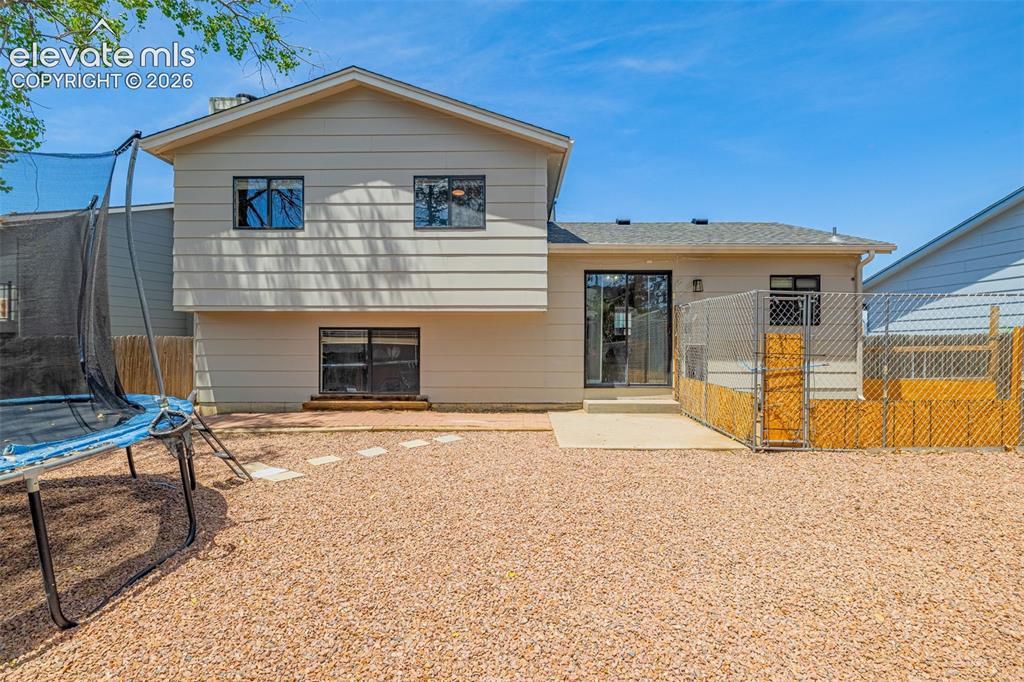 Image 20 of 29: Expansive rear exterior featuring a gravel ground cover, a concrete patio,