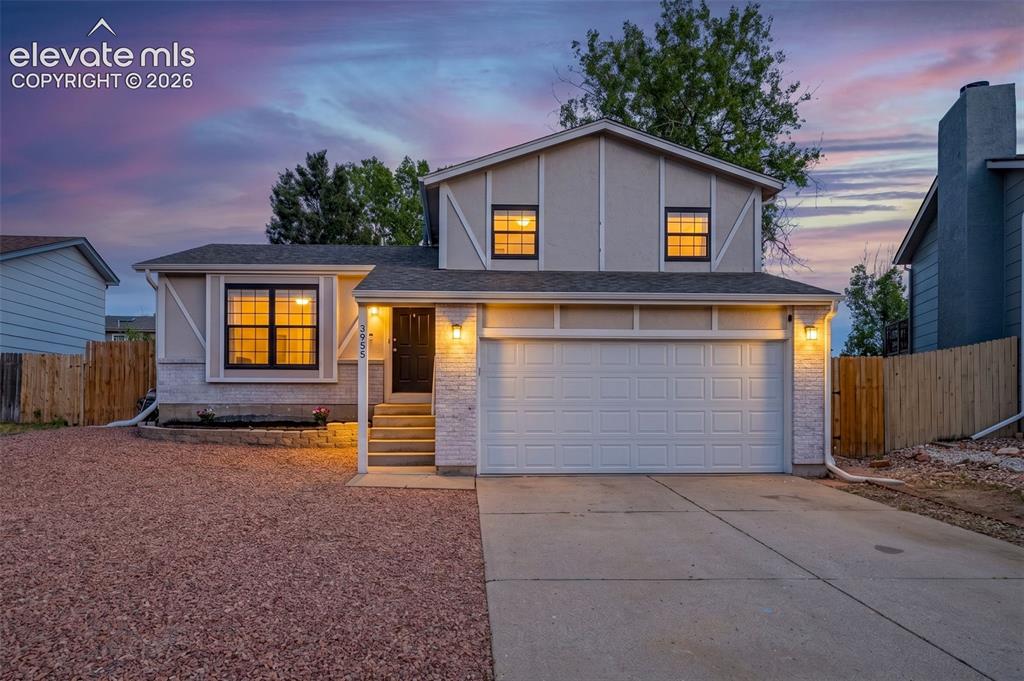Image 3 of 29: Two-story residence featuring a two-car garage with overhead door, concrete