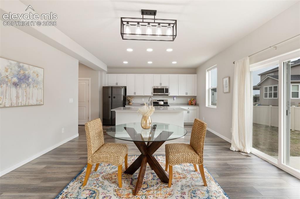 Image 10 of 27: Open-concept kitchen and dining area featuring wood-finish flooring and rec
