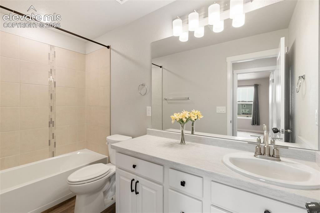 Image 23 of 27: Bathroom featuring a single vanity with white cabinetry, a built-in sink, a
