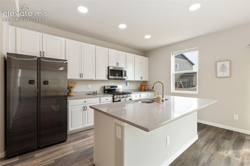 Image 8 of 27: Modern kitchen featuring white cabinetry, stainless steel appliances, gas s