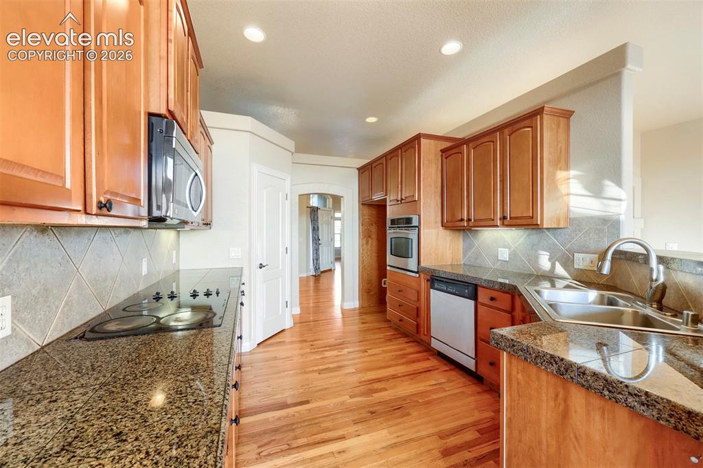 Image 11 of 32: Kitchen features a tile backsplash, abundant cabinetry, and plenty of stora