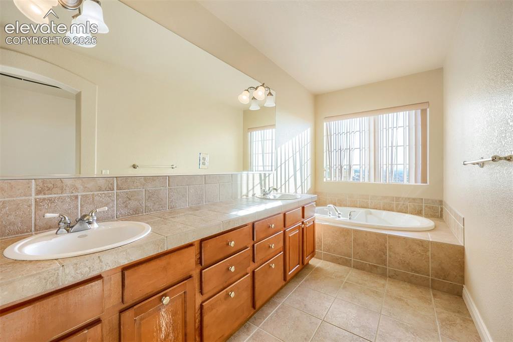 Image 15 of 32: Dual basin vanity 5-piece primary bedroom bath and a built-in soaking tub