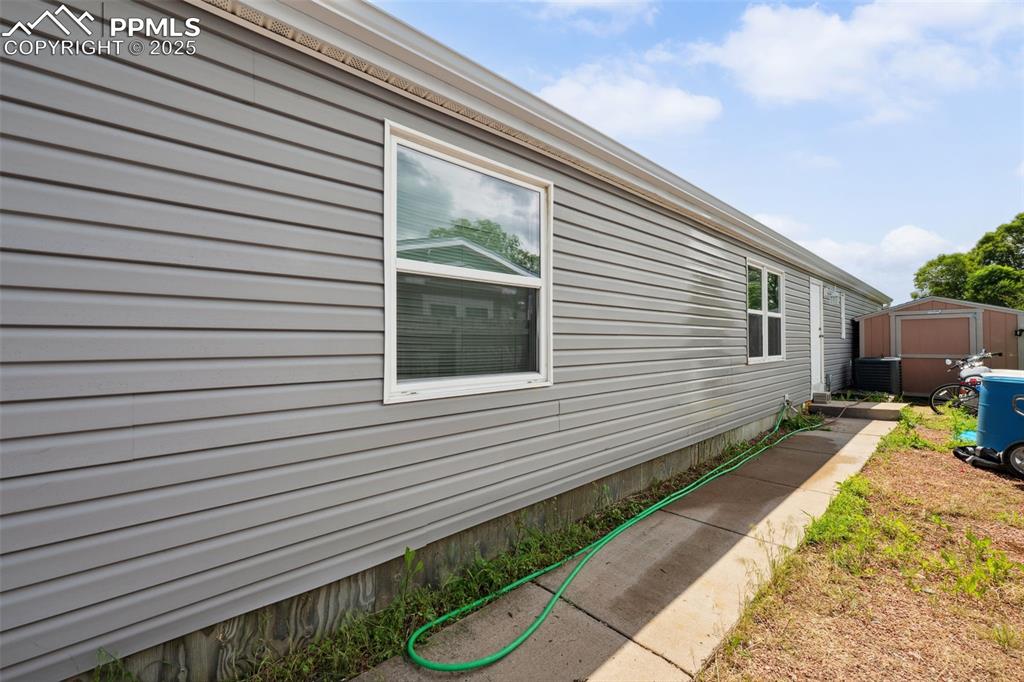 Image 11 of 34: View of side of property with central AC unit