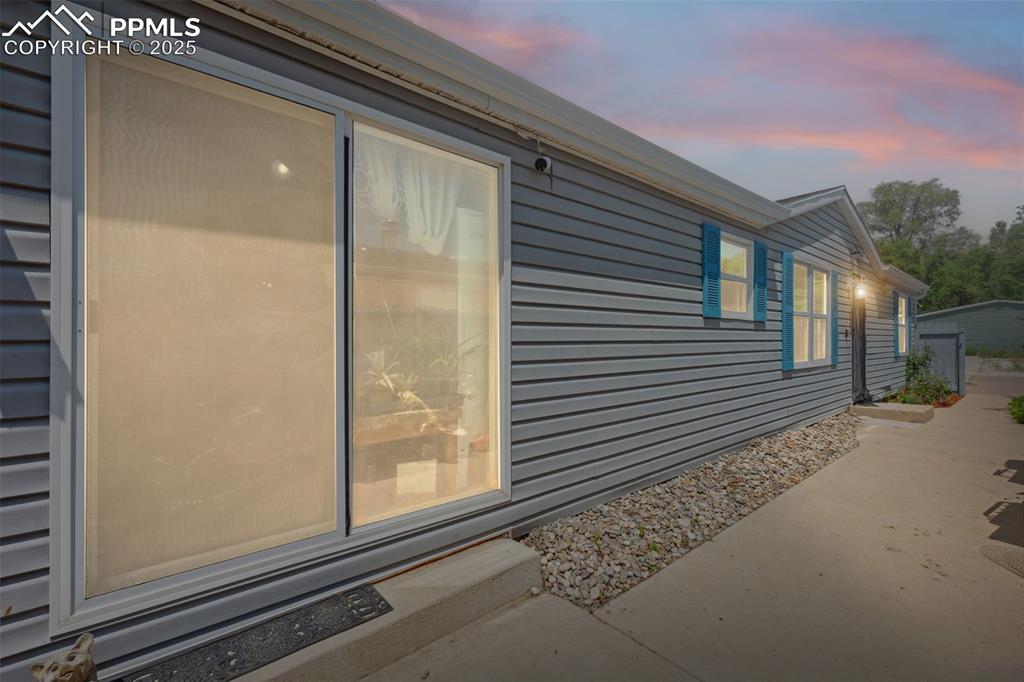 Image 13 of 34: Property exterior at dusk with a patio