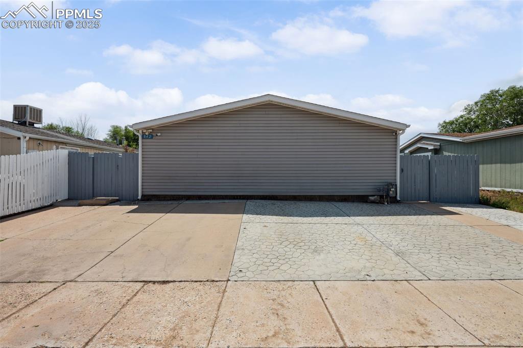 Image 14 of 34: Garage with a gate and central AC unit