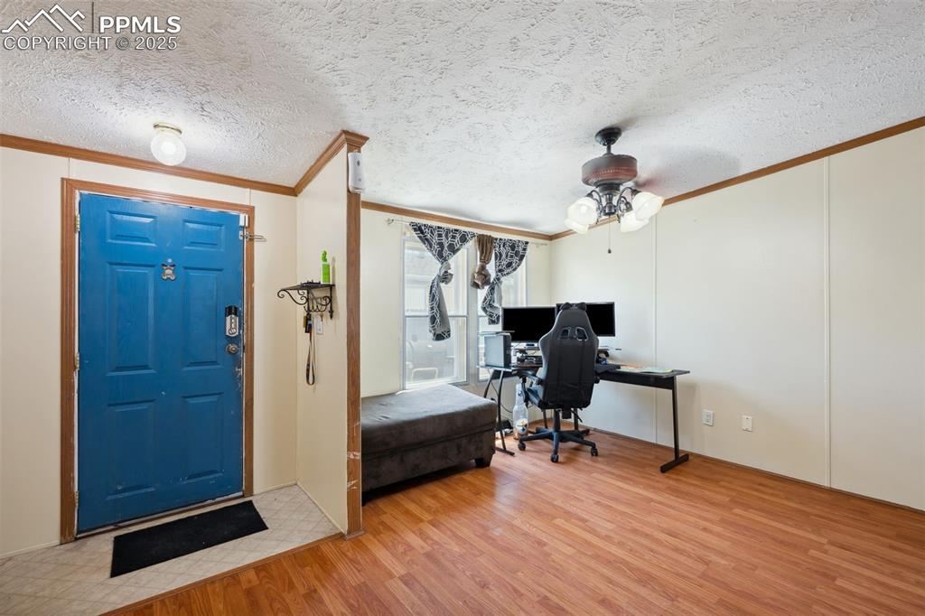 Image 16 of 34: Foyer featuring ornamental molding, wood finished floors, a ceiling fan, an