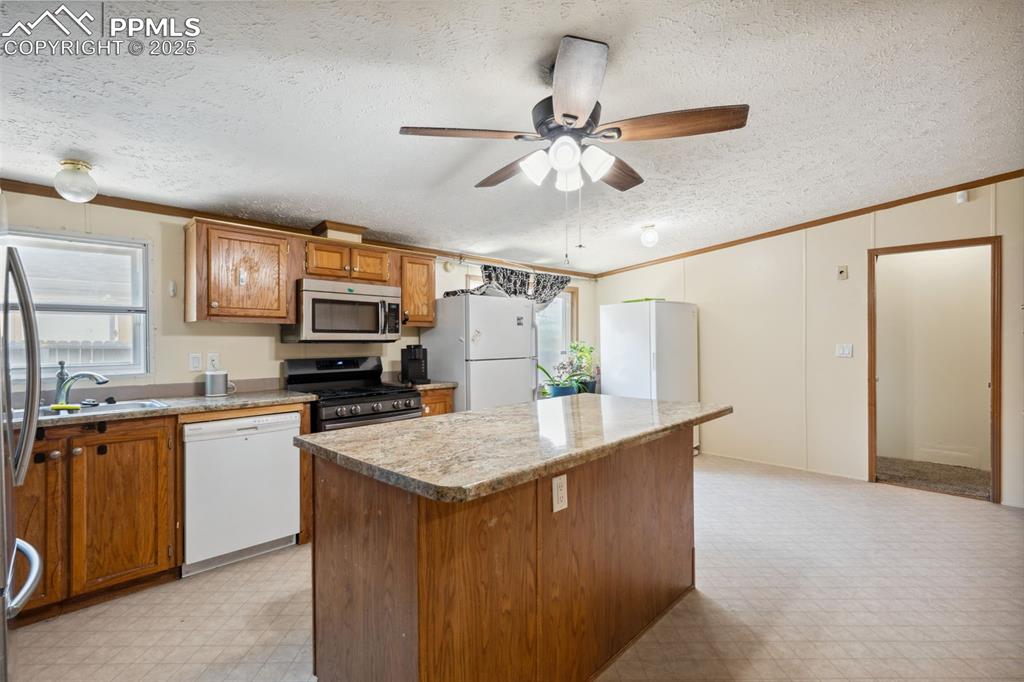 Image 19 of 34: Kitchen with appliances with stainless steel finishes, ornamental molding,