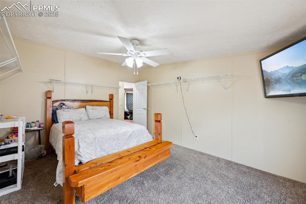 Image 33 of 34: Carpeted bedroom with ceiling fan