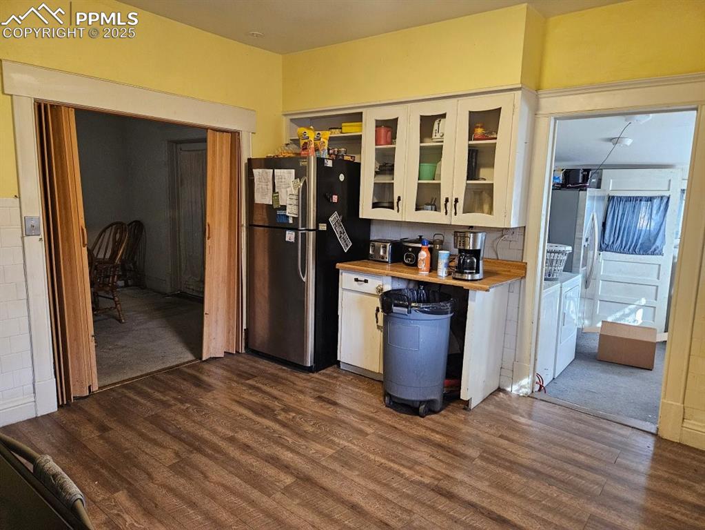 Image 13 of 14: Kitchen featuring white cabinets, washing machine and clothes dryer, stainl