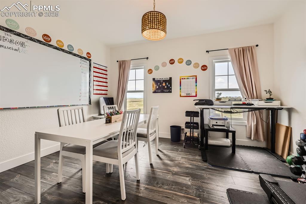 Image 17 of 29: Dining room featuring dark wood-type flooring and baseboards