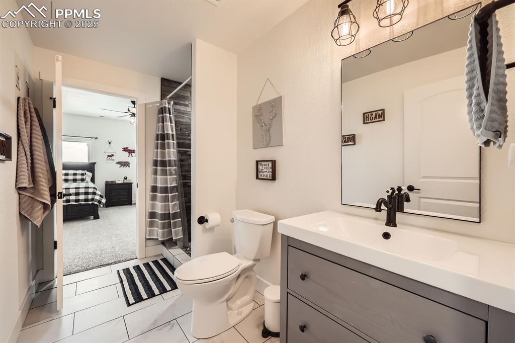 Image 23 of 29: Bathroom with vanity, a shower with shower curtain, tile patterned floors,