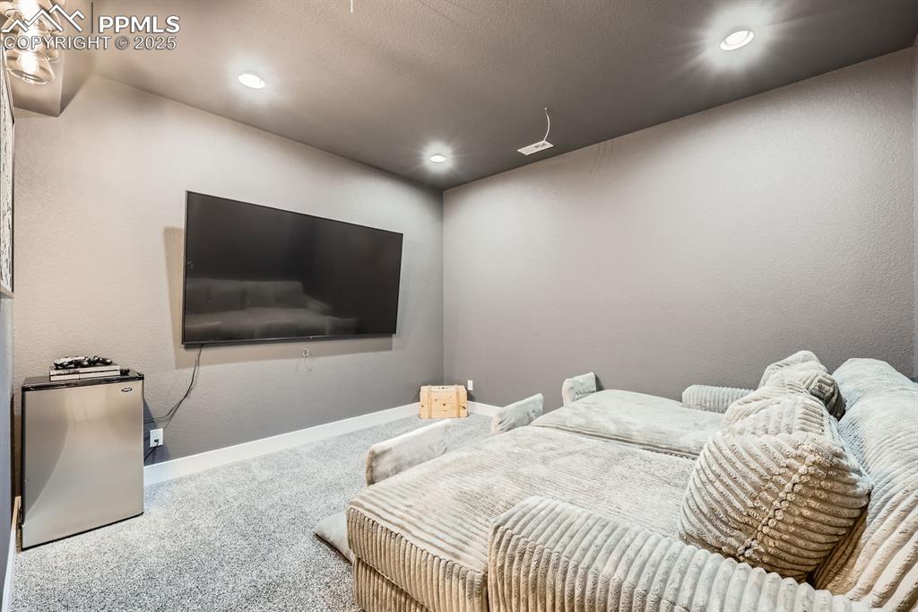 Image 24 of 29: Bedroom featuring carpet floors, a textured wall, recessed lighting, and re