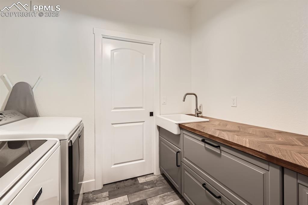Image 25 of 29: Washroom with independent washer and dryer, cabinet space, and wood finishe