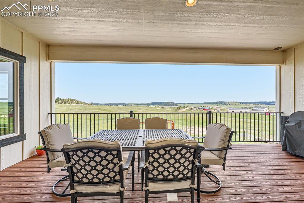Image 26 of 29: Wooden terrace with outdoor dining space, area for grilling, and a view of
