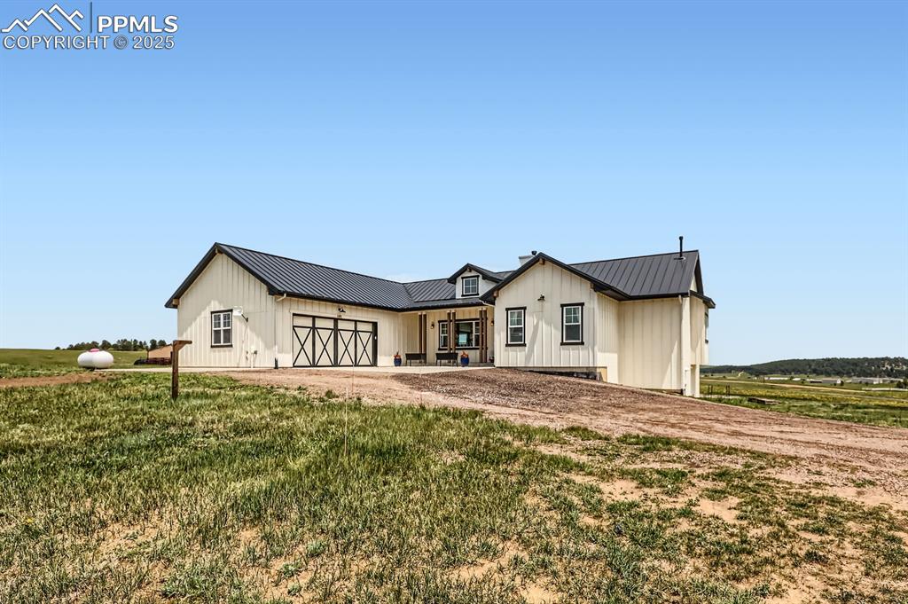 Image 3 of 29: View of front of house featuring a metal roof, board and batten siding, and