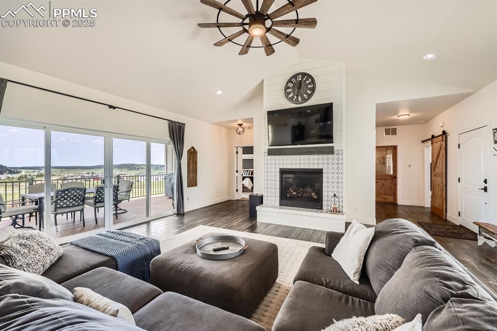 Image 6 of 29: Living room with ceiling fan, dark wood finished floors, lofted ceiling, a