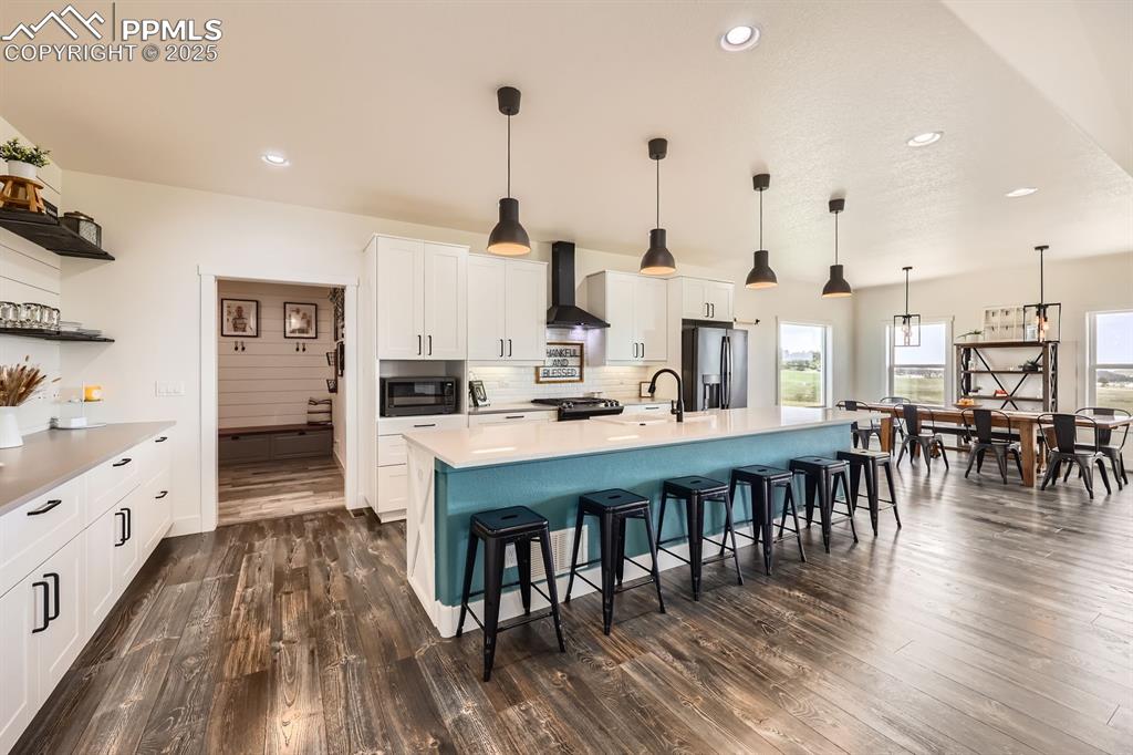 Image 9 of 29: Kitchen featuring a breakfast bar, recessed lighting, white cabinetry, a sp