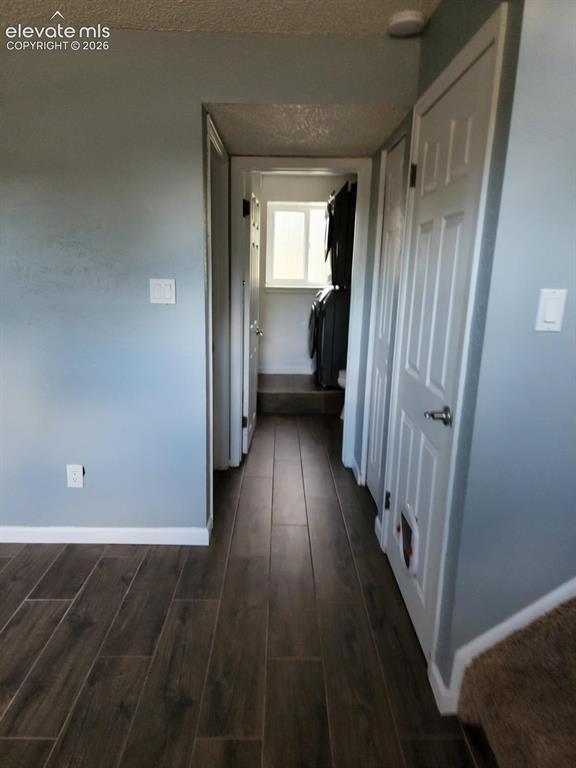 Image 9 of 12: Hallway featuring wood-finish tile flooring, light-toned wall paint, and wh