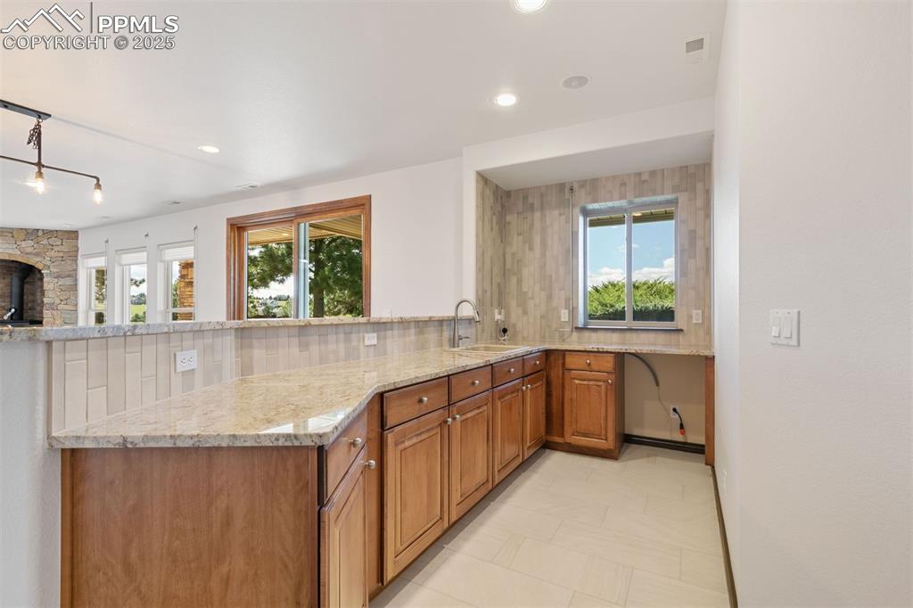 Image 43 of 50: Wet bar with custom cabinetry